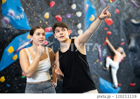 Athletes stand and discuss climbing new bouldering course.girl listens in surprise to male friend Athletes stand and discuss climbing new bouldering course.girl listens in surprise to male friend 120211119
