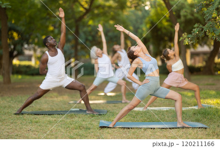 Group pilates and yoga classes in summer park for people of different nationalities Group pilates and yoga classes in summer park for people of different nationalities 120211166