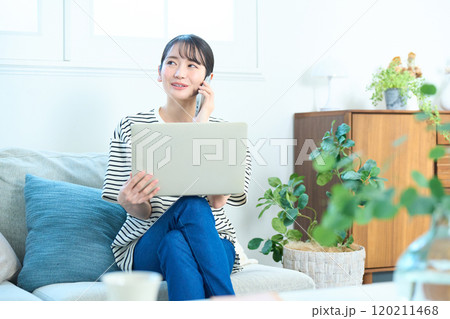 電話をする若い女性　リビング　ワンルーム 120211468