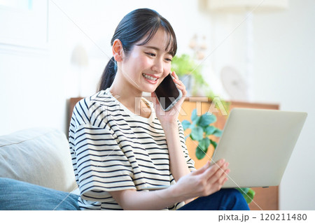 パソコン画面を見る若い女性 リビング ワンルーム パソコン画面を見る若い女性 リビング ワンルーム 120211480