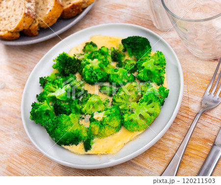Omelette with broccoli served on plate Omelette with broccoli served on plate 120211503