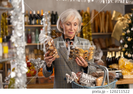 Elderly woman choosing cookies at grocery store Elderly woman choosing cookies at grocery store 120211522