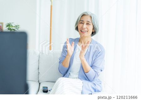 リビングでテレビを見るシニア女性 リビングでテレビを見るシニア女性 120211666