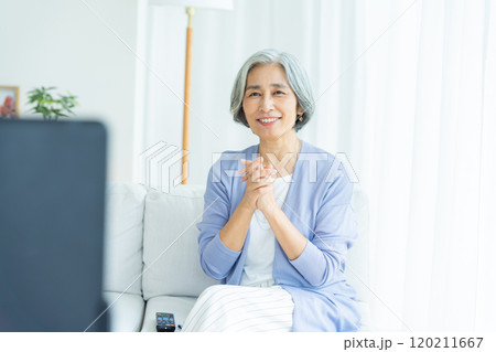 リビングでテレビを見るシニア女性 リビングでテレビを見るシニア女性 120211667