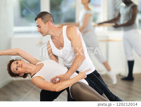 Man and girl woman together arabesque position of ballet during choreography studio Man and girl woman together arabesque position of ballet during choreography studio 120212014