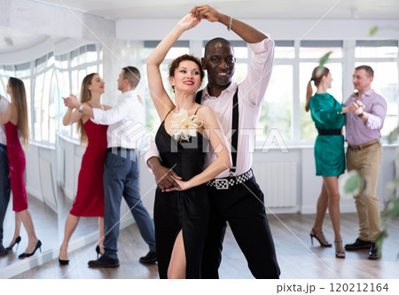 Woman with African man dancing waltz in couple during lesson at studio Woman with African man dancing waltz in couple during lesson at studio 120212164