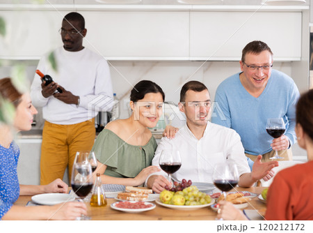 Multiethnic women and men friends chatting and drinking 120212172