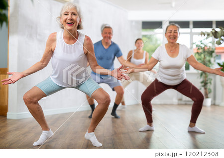Portrait of active mature women enjoying modern energetic dancing in group in the studio 120212308