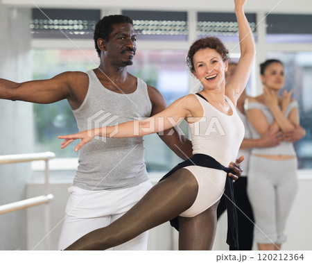 Rehearsing ballet movements in dance studio - man and woman performing adagio 120212364