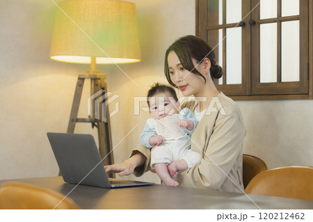 赤ちゃんを抱っこして仕事するスーツを着た女性 赤ちゃんを抱っこして仕事するスーツを着た女性 120212462