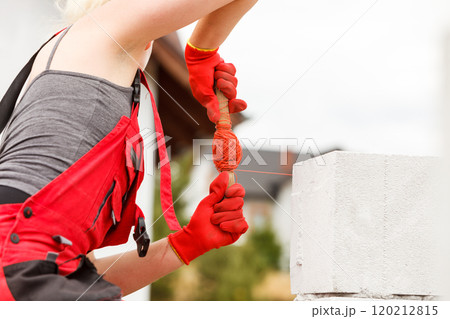 Woman leveling airbricks on construction site 120212815