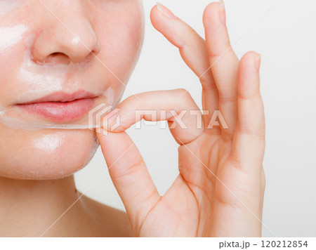 Woman removing facial peel off mask. Woman removing facial peel off mask. 120212854