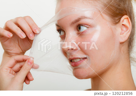 Woman removing facial peel off mask. 120212856