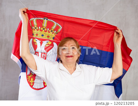 Smiling senior woman waving national flag of Serbia 120213205
