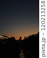 夕焼けの川の向こうに見えるビル 120213258