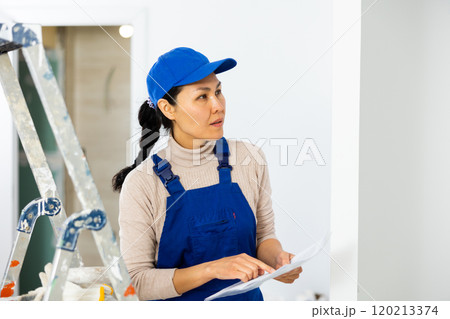 Female engineer matching check list during repair works 120213374