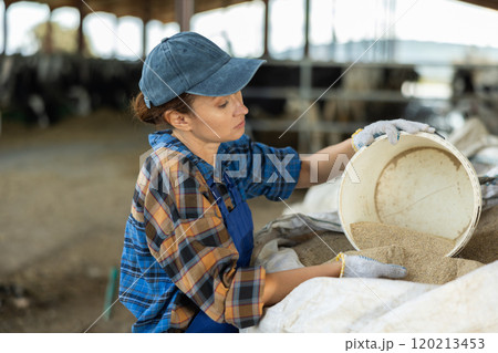 Adult woman scooping sand from bag Adult woman scooping sand from bag 120213453