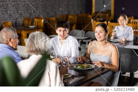 Elderly couple and young couple having dinner in restaurant Elderly couple and young couple having dinner in restaurant 120213480