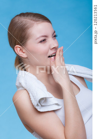 Bored sleepy woman yawning while holding towel 120213561