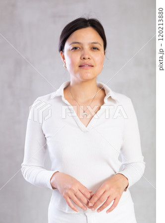 Calm middle-aged woman poses on gray background Calm middle-aged woman poses on gray background 120213880