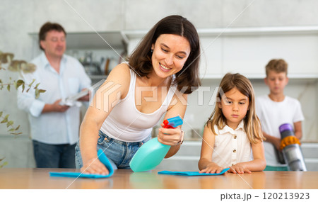 Little girl helps mother wash kitchen table. Little girl helps mother wash kitchen table. 120213923