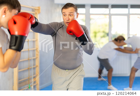 Two men training boxing fight in studio 120214064