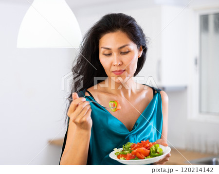 Portrait of asian woman eating salad at home Portrait of asian woman eating salad at home 120214142