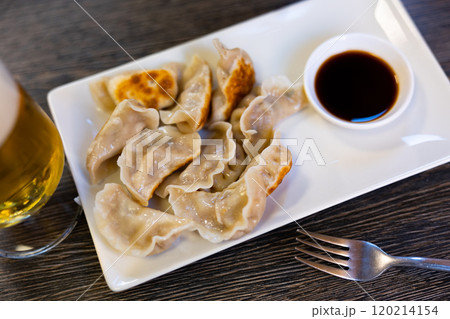 in oriental restaurant, plate of fried Chinese dumplings and bowl of soy sauce is served for lunch 120214154