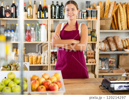 Young woman seller at counter in grocery store 120214297