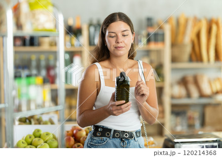 Young woman choosing olive oil in grocery store Young woman choosing olive oil in grocery store 120214368