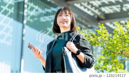 屋外でスマホを持つ若い女性・ビジネスウーマン 120214517