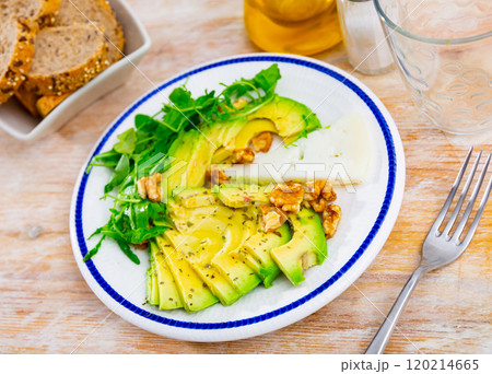 Avocado and cheese served with arugula and walnuts 120214665