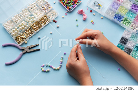 Creating colorful beaded jewelry with vibrant materials on a crafting table 120214886