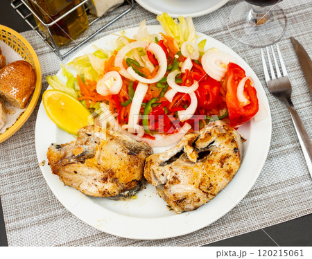 Healthy vegetarian dinner of baked hake steaks with vegetables salad and slice of lemon Healthy vegetarian dinner of baked hake steaks with vegetables salad and slice of lemon 120215061