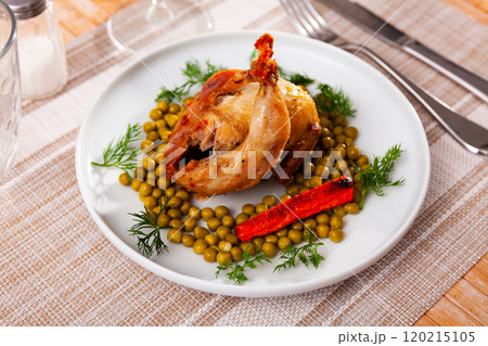 Roasted whole quail with peas on plate 120215105