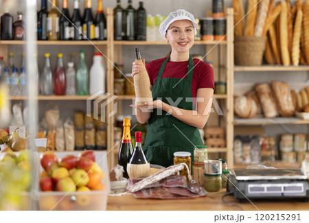 Young woman seller with wine in grocery store Young woman seller with wine in grocery store 120215291