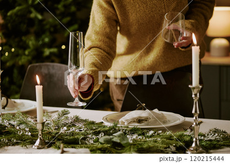 Unrecognizable woman in elegant clothes holding polished crystal glasses for juice and champagne 120215444