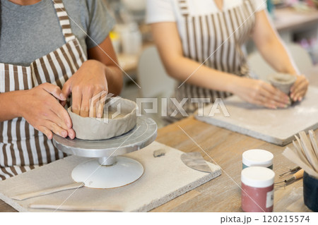 Female hands sculpting clay product close-up 120215574