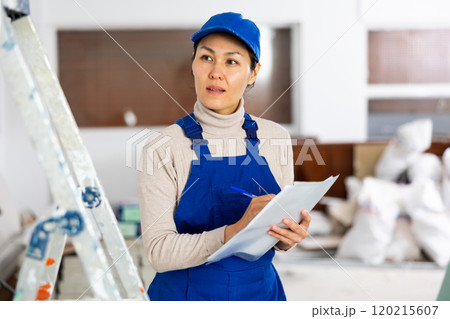 Female engineer matching check list during repair works Female engineer matching check list during repair works 120215607