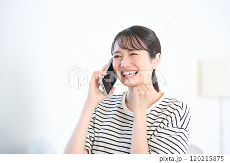 リビングで通話をする若い女性　リビング　ワンルーム 120215875