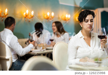 Sad woman with glass at the restaurant 120215998