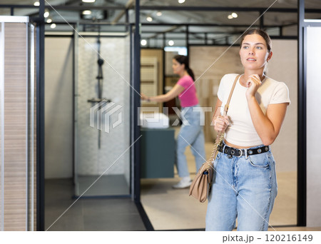 Girl chooses bathroom accessories with interest in hardware store 120216149
