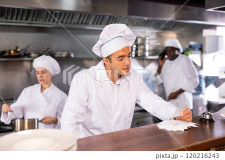 Chef reads the paid check before starting to prepare food Chef reads the paid check before starting to prepare food 120216243