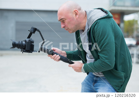 Cameraman making video outdoors Cameraman making video outdoors 120216320