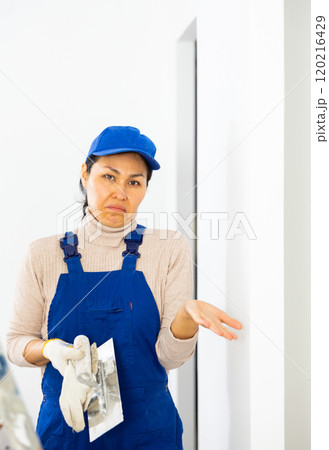 Portrait of frustrated woman builder standing in apartment Portrait of frustrated woman builder standing in apartment 120216429