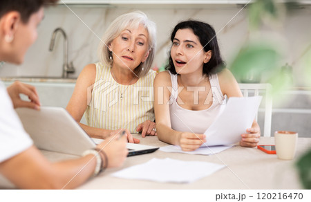 Elderly and young female clients listen attentively and intently to male seller Elderly and young female clients listen attentively and intently to male seller 120216470