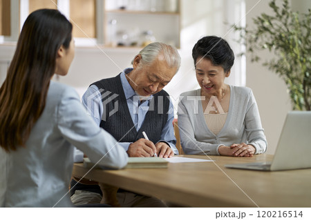 senior asian couple signing a contract at home senior asian couple signing a contract at home 120216514