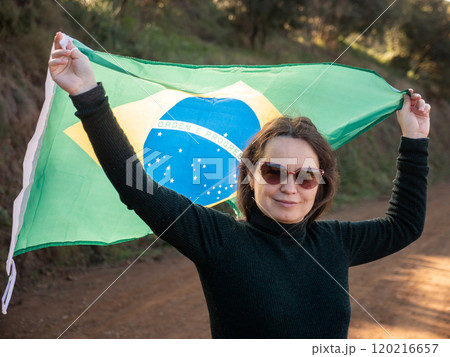 Smiling woman holding large flag of Brazil Smiling woman holding large flag of Brazil 120216657