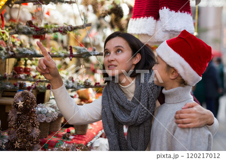 Tween boy with mother choosing Xmas decorations on street fair 120217012