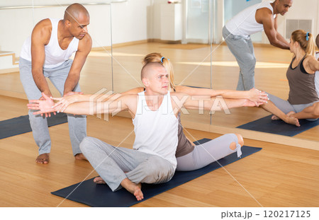 People practicing yoga with partner at studio People practicing yoga with partner at studio 120217125